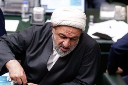 حمیدرضا رسایی در مجلس به جلو خم شده است.