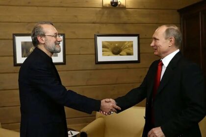 لاریجانی و پوتین با هم دست می‌دهند.